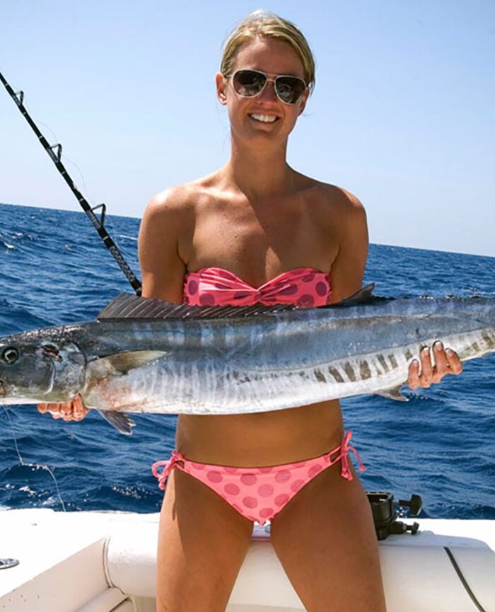 Woman in polka dot bikini holding fish