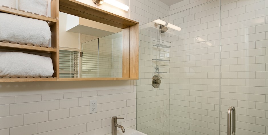 white subway tile bath with glass doors
