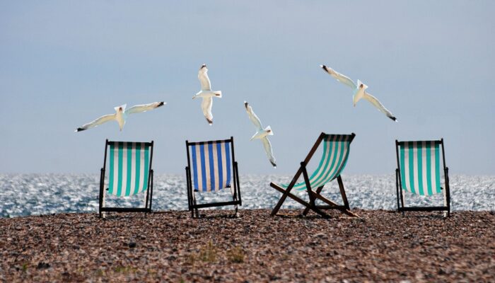 four striped deckchairs and seagulls flying