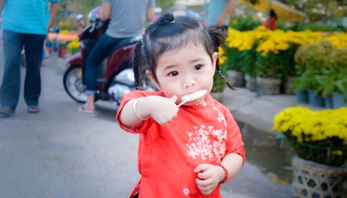 little girl with braids enjoying lollipop