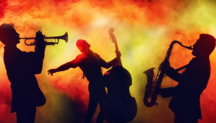 Jazz band in shadow on orange and yellow background smoke