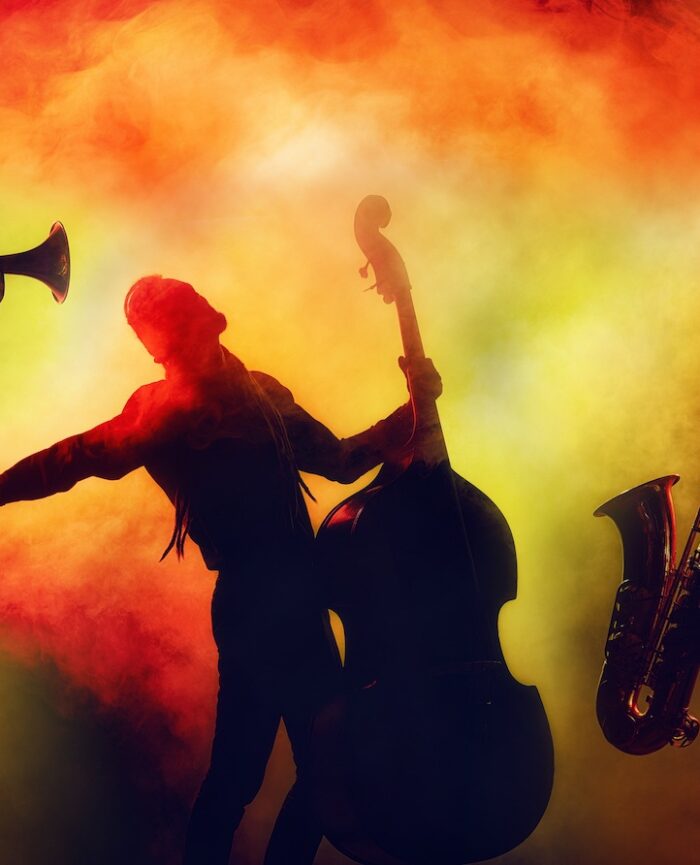Jazz band in shadow on orange and yellow background smoke